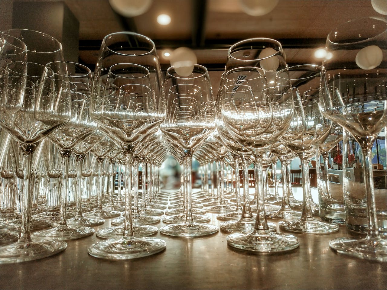 Crystal-clear wine glasses beautifully arranged on a restaurant table, reflecting elegance and sophistication.